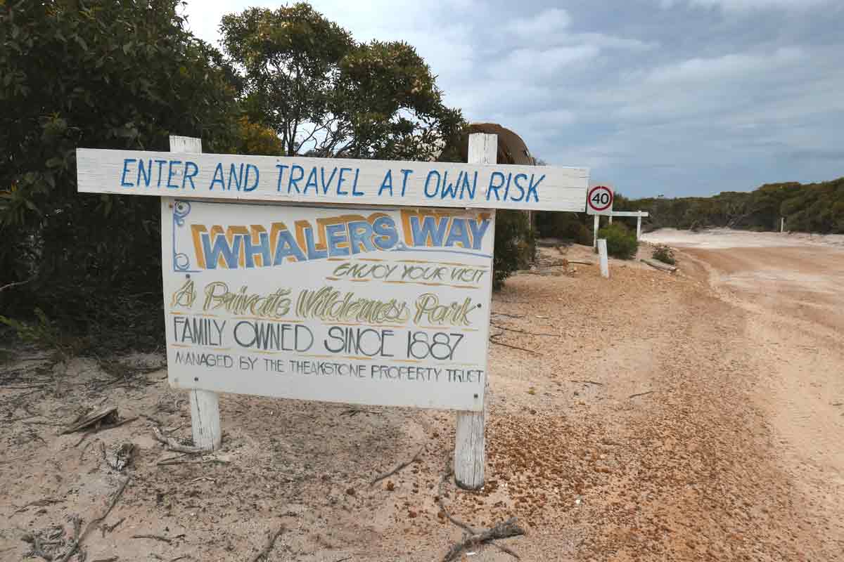 Sign for the sanctuary at the entrance saying 'Enter and travel at own risk'. Located in Whaler's Way Sanctuary, Eyre Peninsula, South Australia.